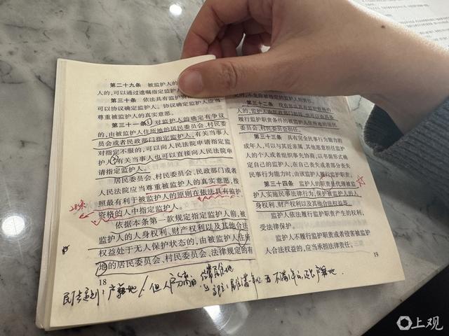 邓敏办公桌上快“翻烂”的《民法典》。 舒抒 摄